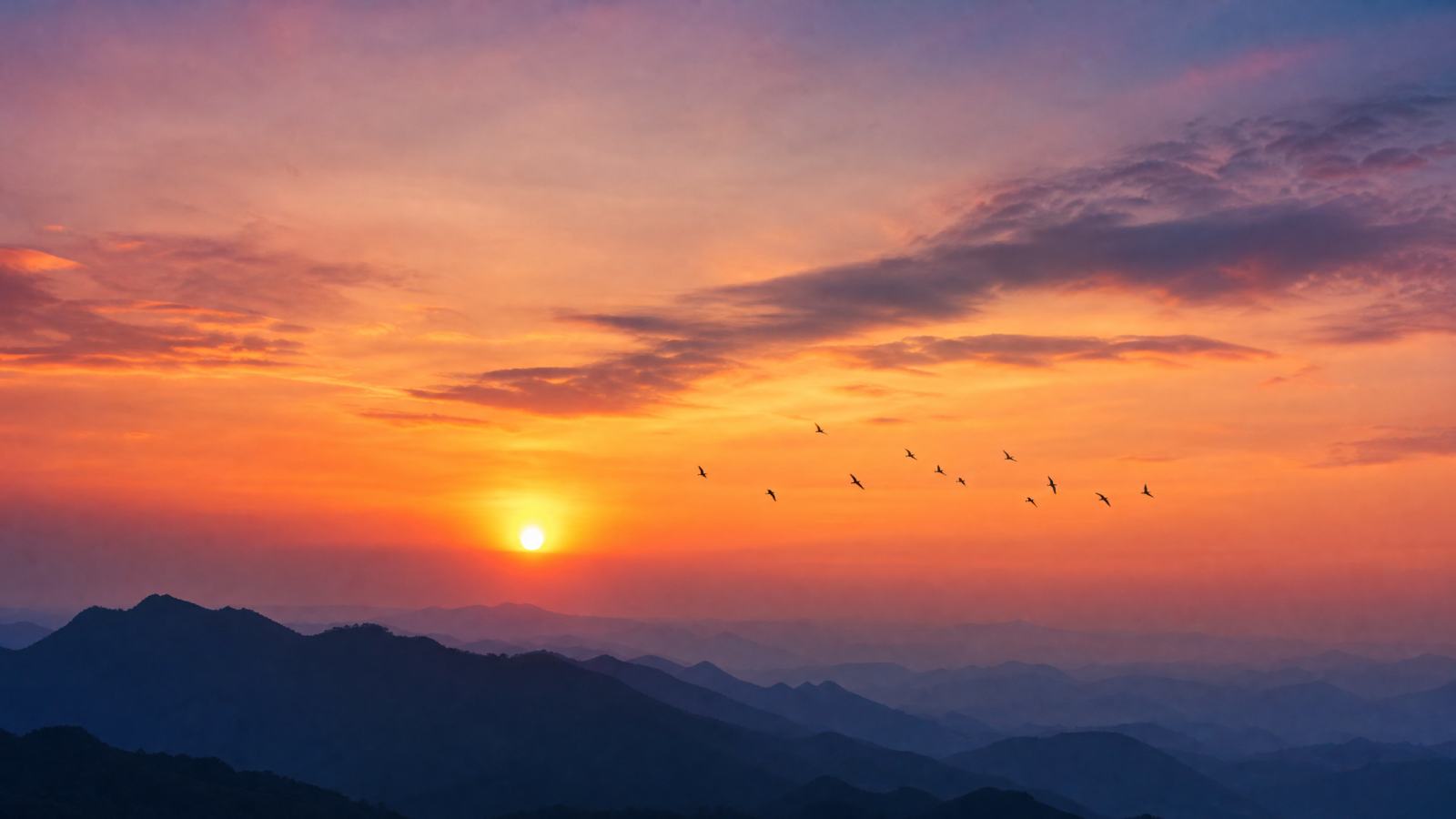 夕阳下的山峦剪影，天空呈现橙色与紫色渐变，远处有飞鸟，摄影风格，高清晰，16:9 - 唯爱壁纸